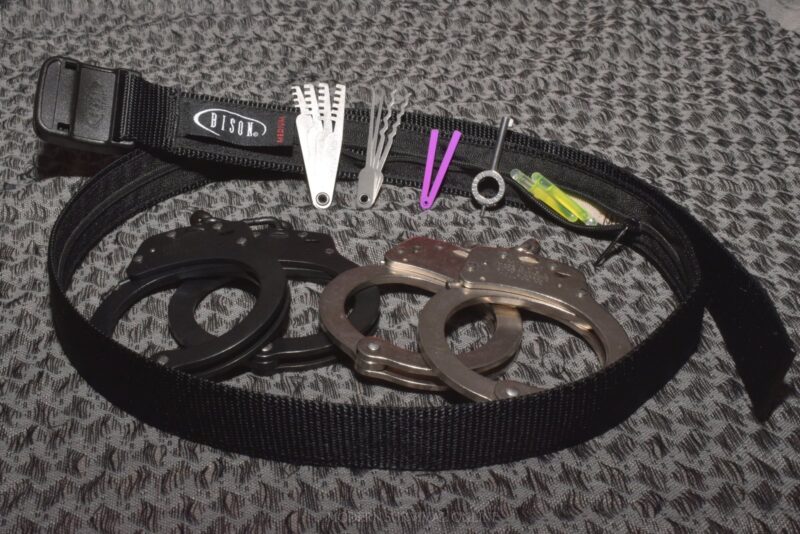 handcuff concealment belt with comb picks, lock picks, handcuff shim (purple), handcuff key, glow stick