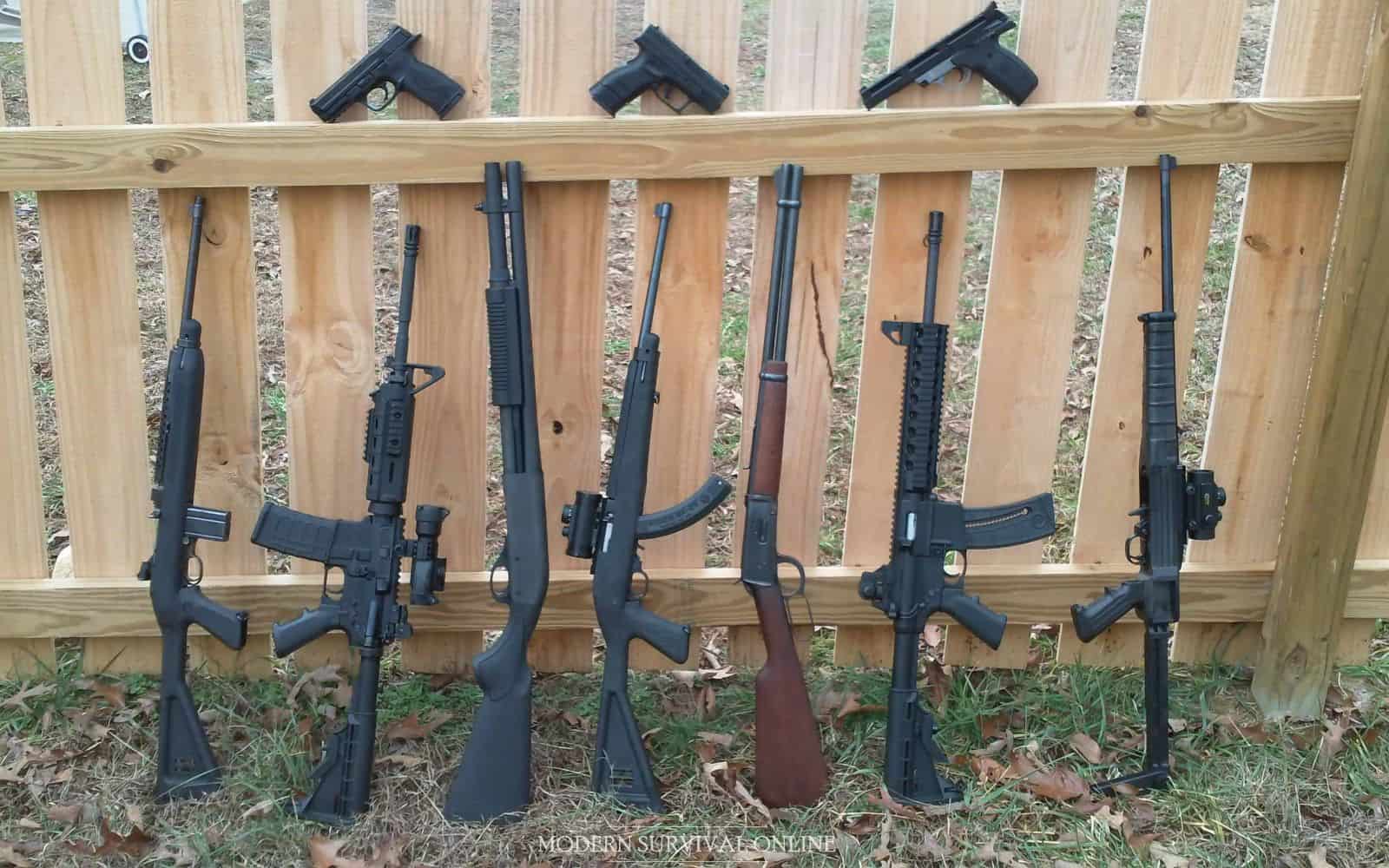 rifles and handguns near wooden wall
