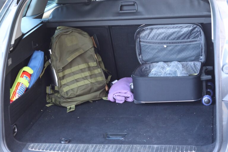 backpack blanket and baggage loaded with water bottles in car trunk